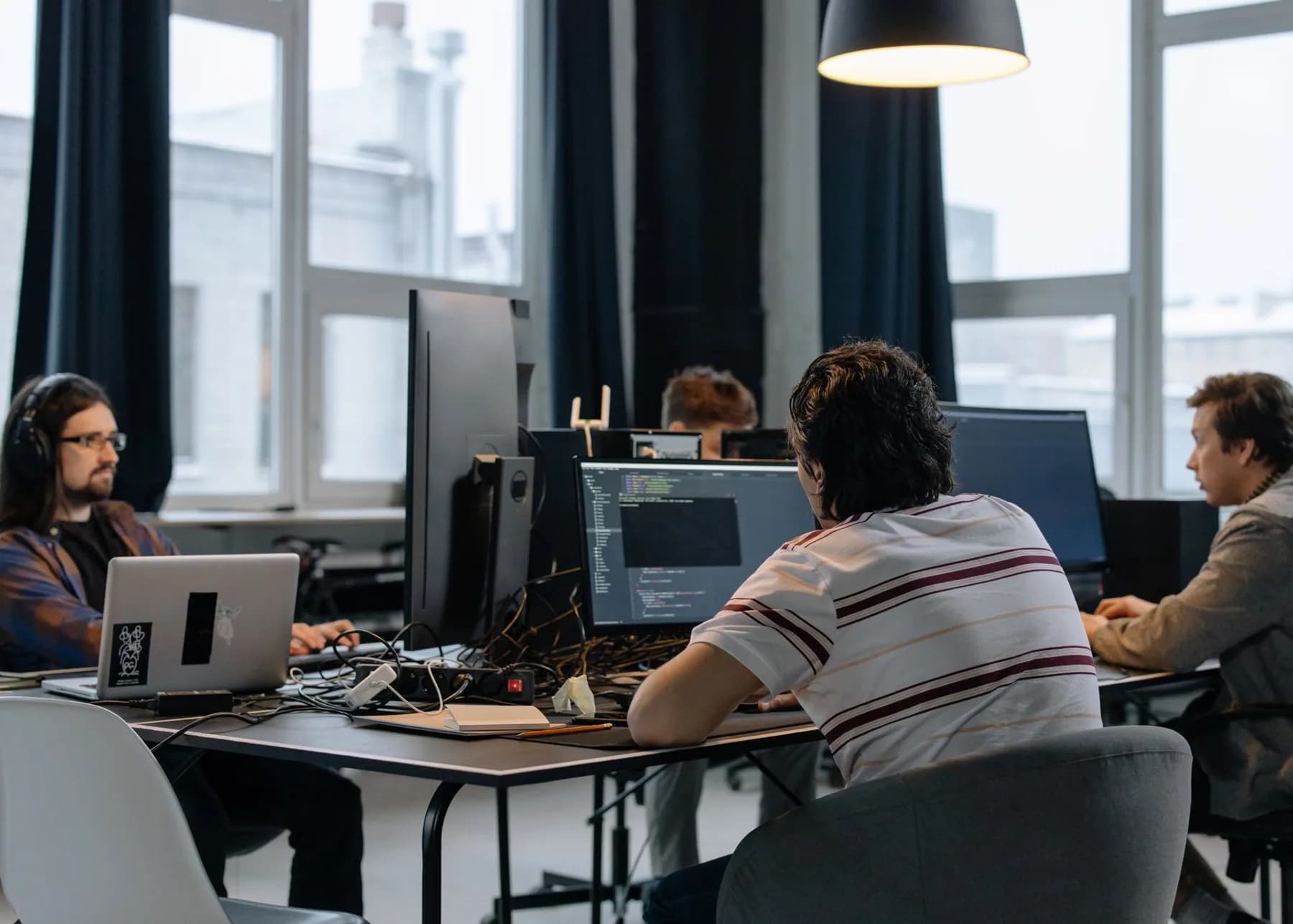 Software developers collaborating at workstations in a modern technology office
